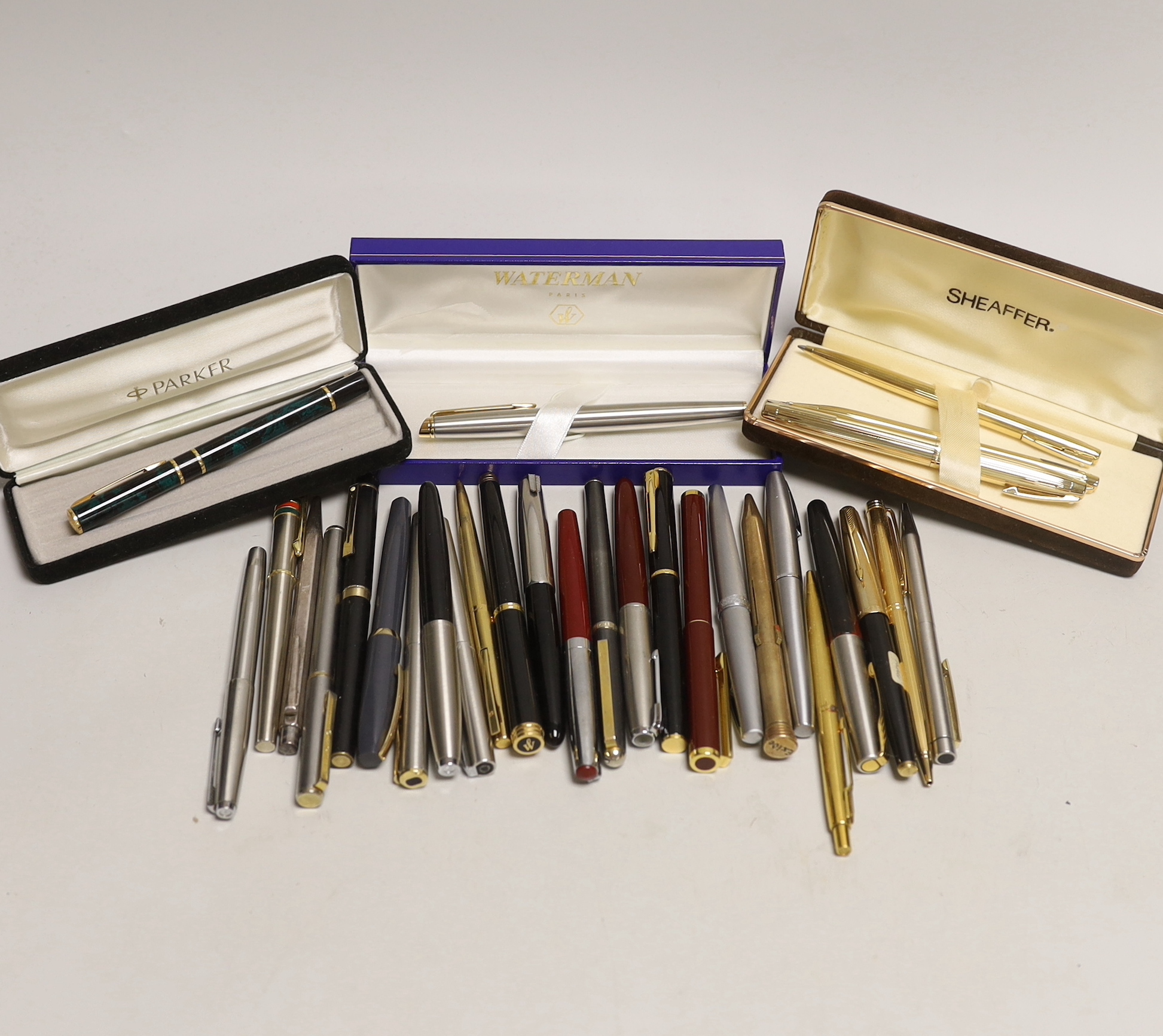 A group of fountain pens and ballpoint pens including a cased Sheaffer set